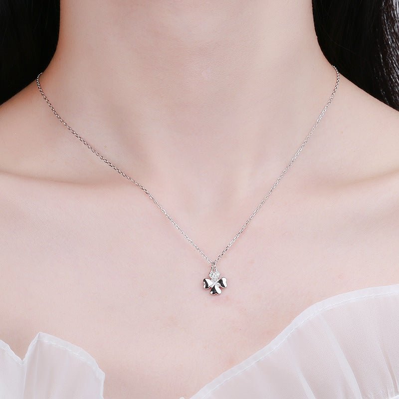Silver necklace with a clover pendant on a model
