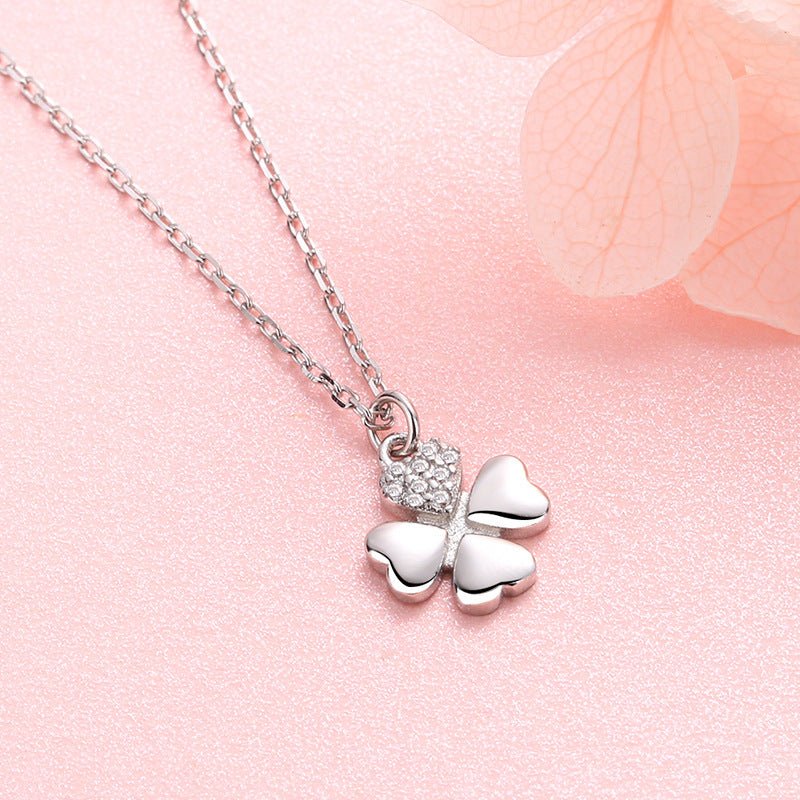 Silver butterfly necklace with clear stones on a pink floral background