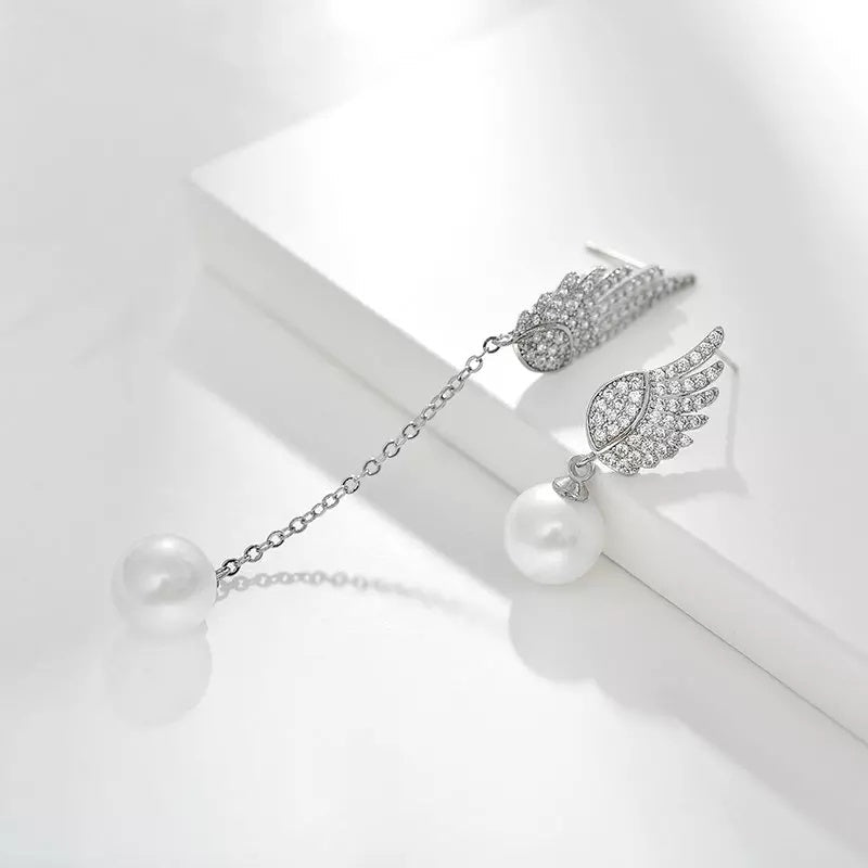 Silver earring with gemstones and pearls on a white background