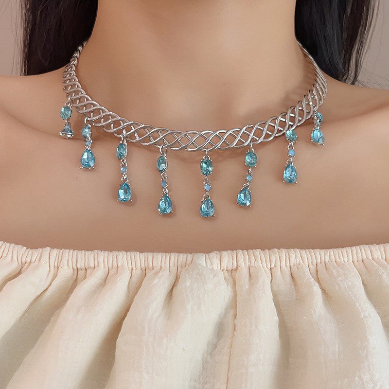 Necklace with blue gemstones worn by a model against a neutral background