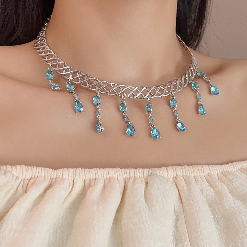 Necklace with blue stones worn by a model against a neutral background