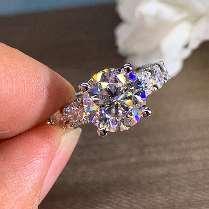 Diamond ring held between fingers with a blurred background