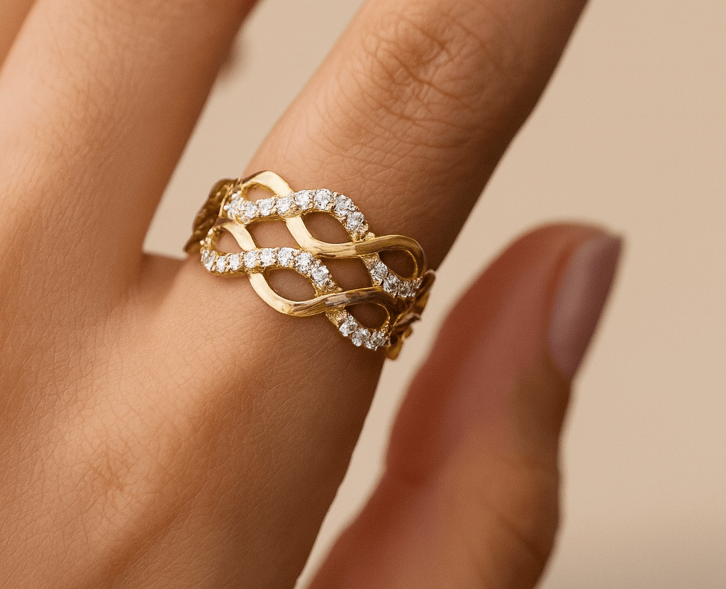 Gold ring with diamonds on a finger against a beige background