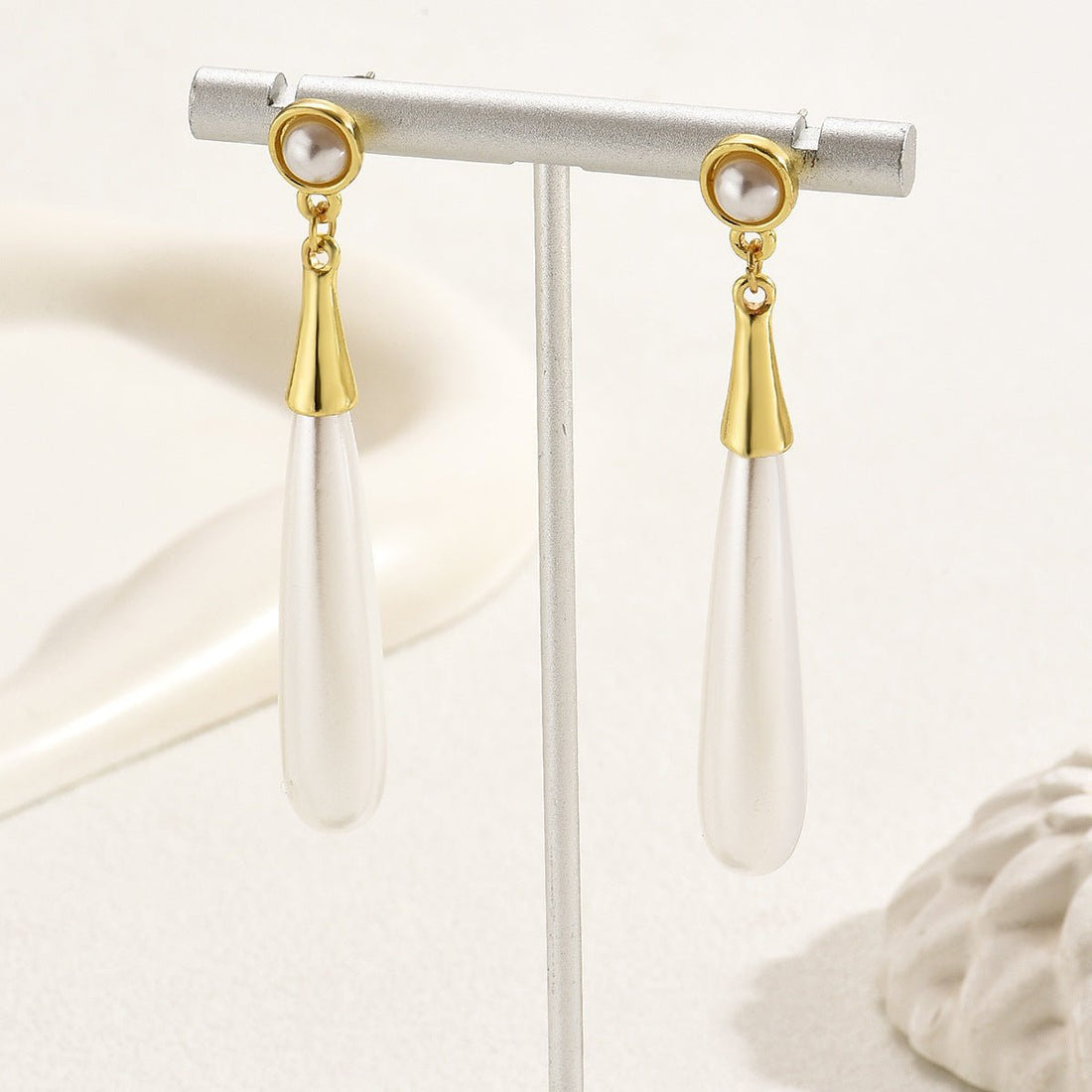 Pearl earrings with gold accents on a white background