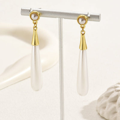 Pearl earrings with gold accents on a white background
