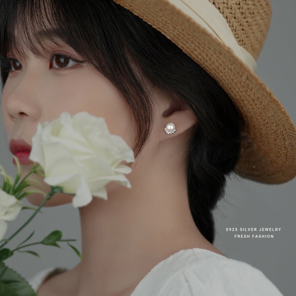 Woman wearing a straw hat and pearl earring with a white rose, brand '925 Silver Jewelry' visible.