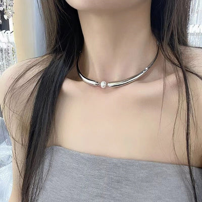 Silver necklace with a pearl pendant worn by a person with long dark hair.
